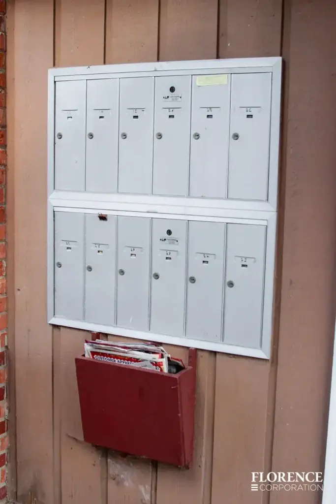 1250 recessed mounted vertical 4B+ mailboxes in anodized aluminum installed on brown wall over magazine collection box