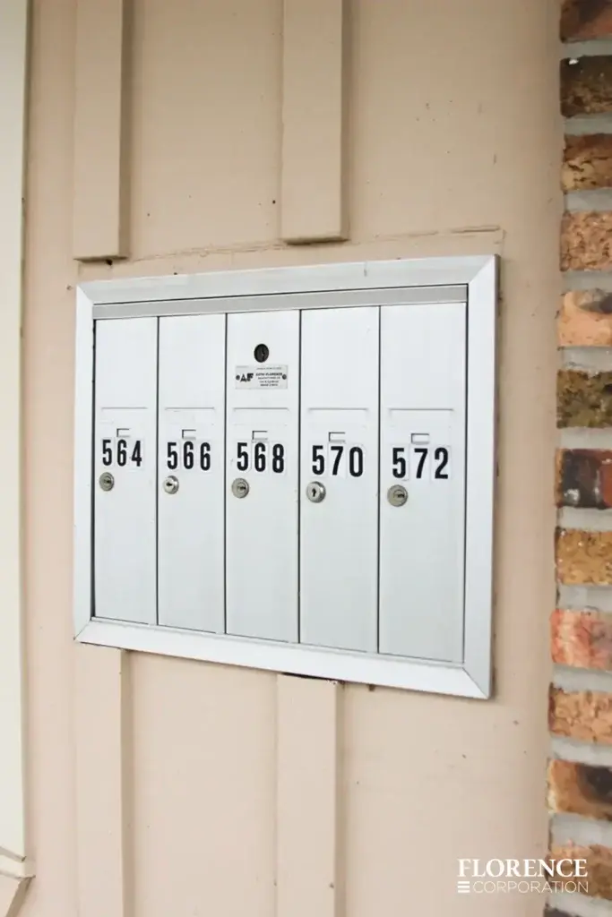 1250 recessed mounted vertical 4B+ mailboxes in anodized aluminum with custom number decals installed on wall next to brick