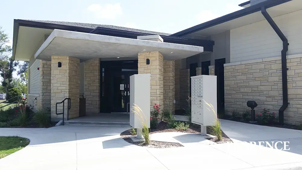 vital&trade; cluster box units in postal grey installed in front of commercial building space with rock stone exterior walls