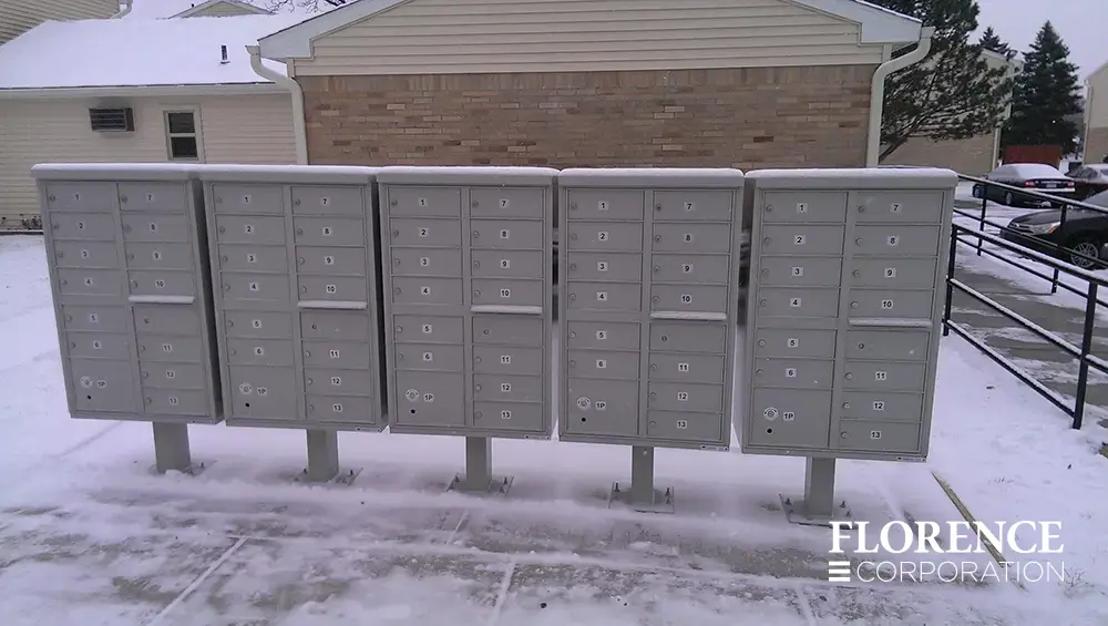 vital&trade; cluster box units in postal grey installed outdoors on a snowy winter day near apartment complex parking lot