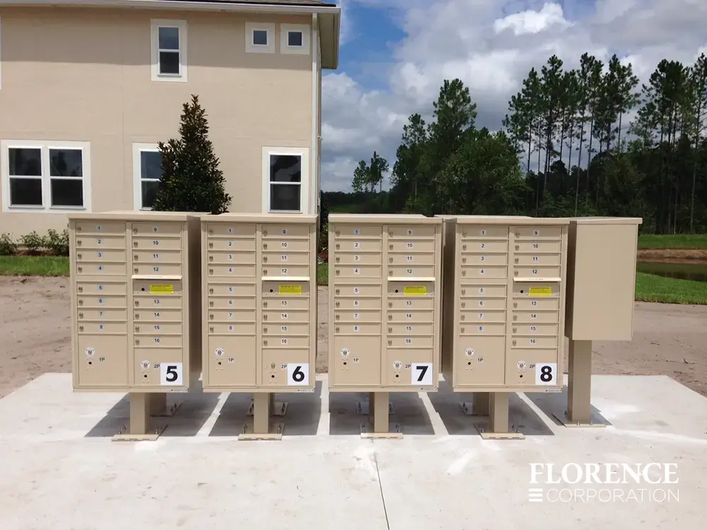vital&trade; cluster box units in sandstone installed back to back with large number labels near multifamily apartments on concrete slab