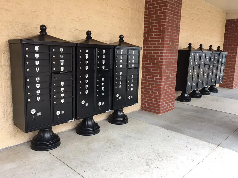 vogue&trade; accessories on vital&trade; cluster box units in black installed along wall of commercial building