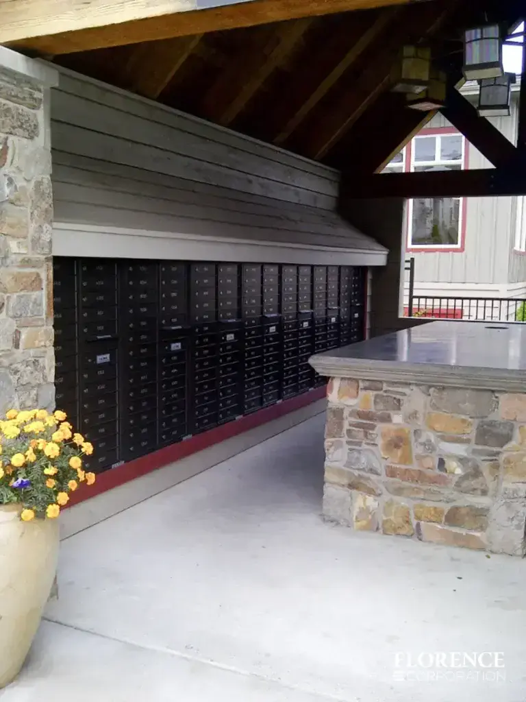 recessed mounted versatile&trade; 4C mailboxes in black installed outdoor under covered gazebo with floral planters and stone column