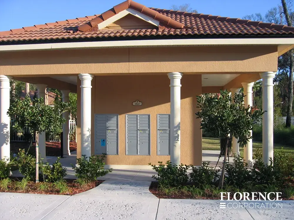 recessed mounted versatile&trade; 4C mailboxes in silver speck installed outdoors under orange spanish tile pavilion surrounded by green landscaping
