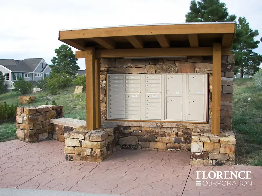 recessed mounted versatile&trade; 4C mailboxes in sandstone installed in custom-built wood and stone fixture outdoors in town home community