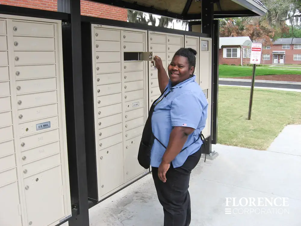 recessed mounted versatile&trade; 4C mailboxes in sandstone with smiling African American women retrieving mail