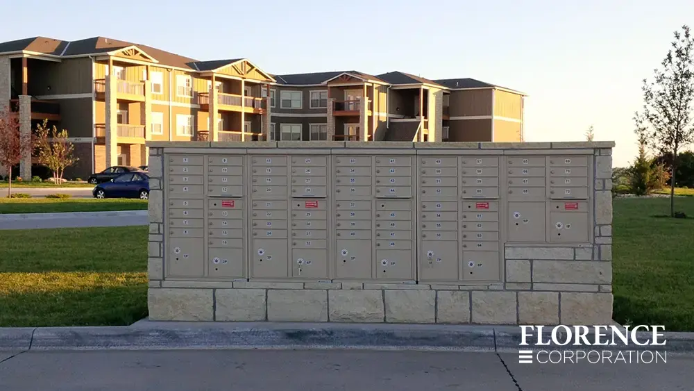 recessed mounted versatile&trade; 4C mailboxes in sandstone installed in rock fixture in parking lot area of multifamily apartment community