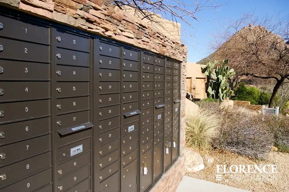 recessed mounted versatile&trade; 4C mailboxes in dark bronze installed in outdoor stone fixture in desert landscape with cactus and desert shrubbery