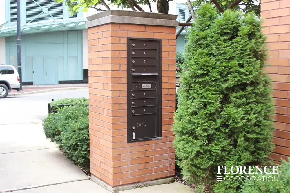 single recessed mounted versatile&trade; 4C mailbox module in dark bronze installed in brick pillar outside commercial space