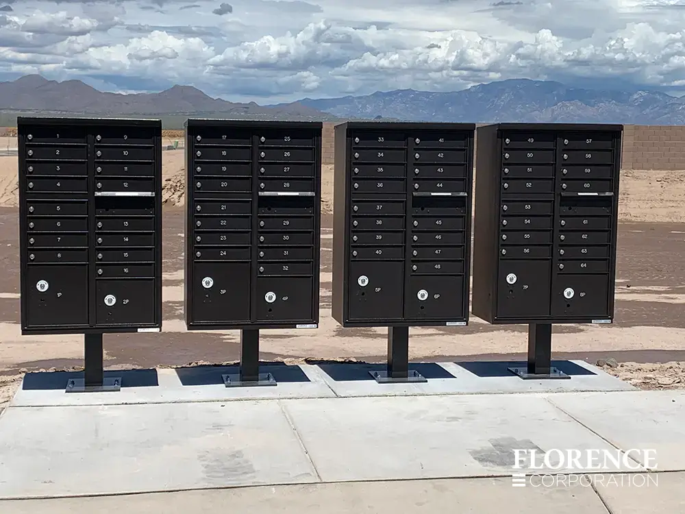 vital&trade; cluster box units in dark bronze installed along sidewalk on a cloudy day with mountains in scenery background