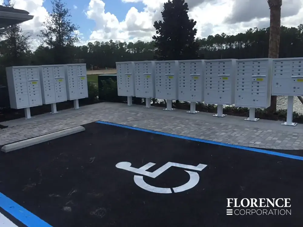 vital&trade; cluster box units in white installed in row near handicap parking spot of community parking lot