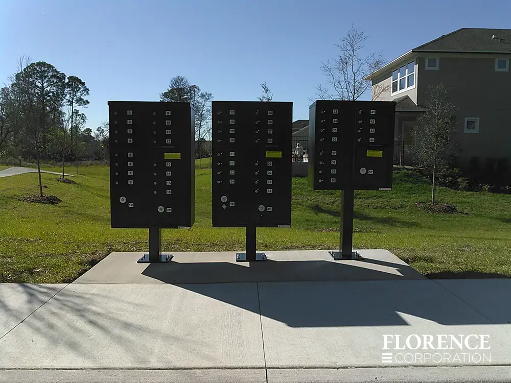 vital&trade; cluster box units in black installed three in a row in single family home community development with sprawling sidewalk and green grass