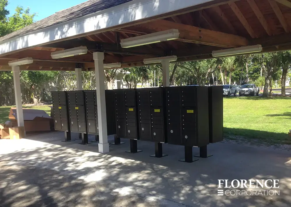 multiple vital&trade; cluster box units in black installed back-to-back under large outdoor gazebo covering near parking lot and grassy park