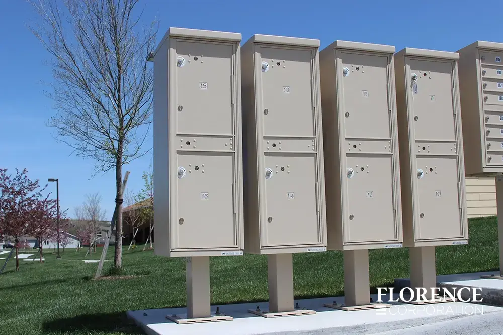 valiant-1590-OPL-series_015 valiant™ outdoor parcel lockers in sandstone installed on concrete slab near grassy yard with new trees