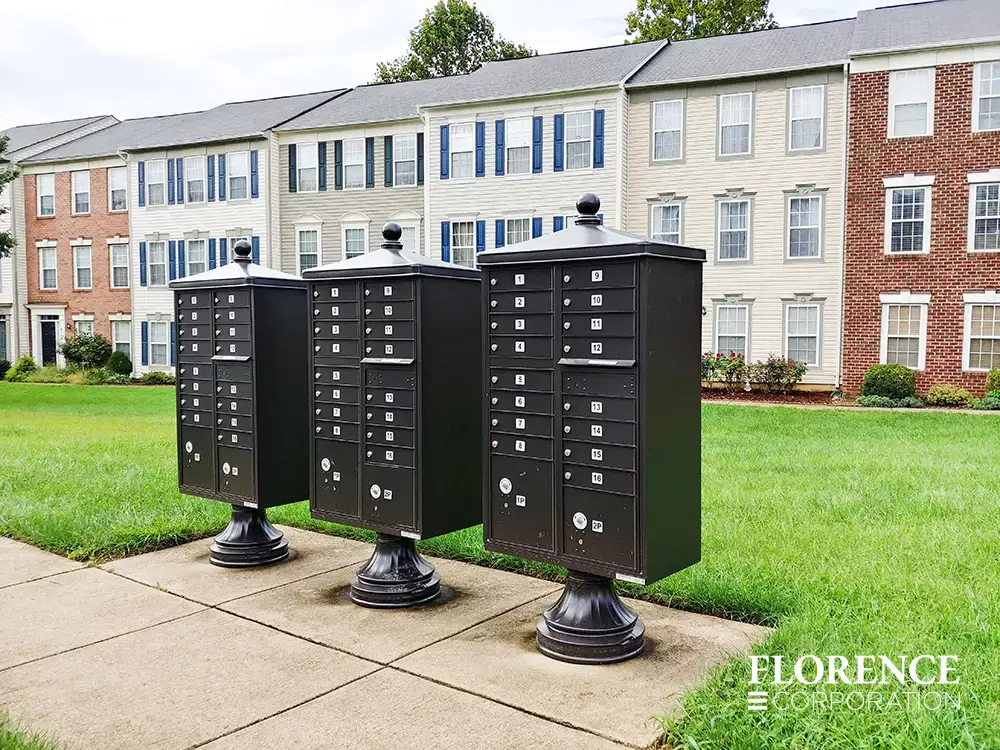 vogue-CBU-Accessories_018 vogue™ accessories on vital™ cluster box units in dark bronze installed outdoor on concrete slab in front of town home apartment style community