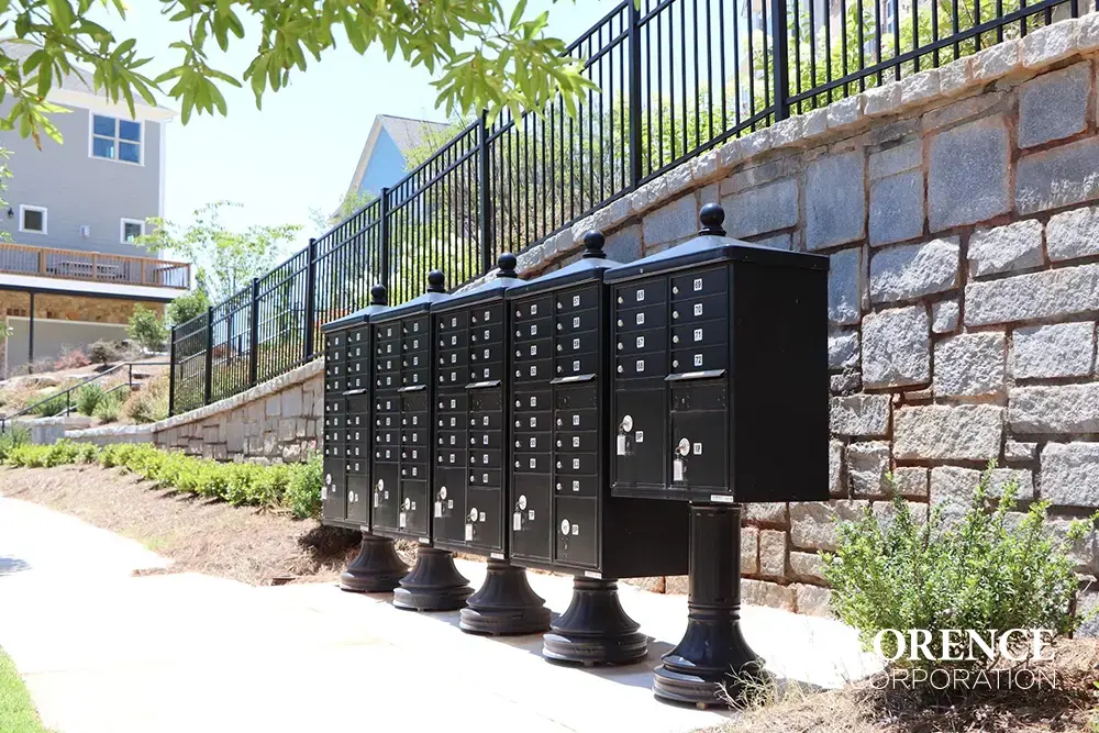 vogue-CBU-Accessories_028 vogue™ accessories on vital™ cluster box units in black installed in multifamily community along sidewalk backed up to stone wall with black railing
