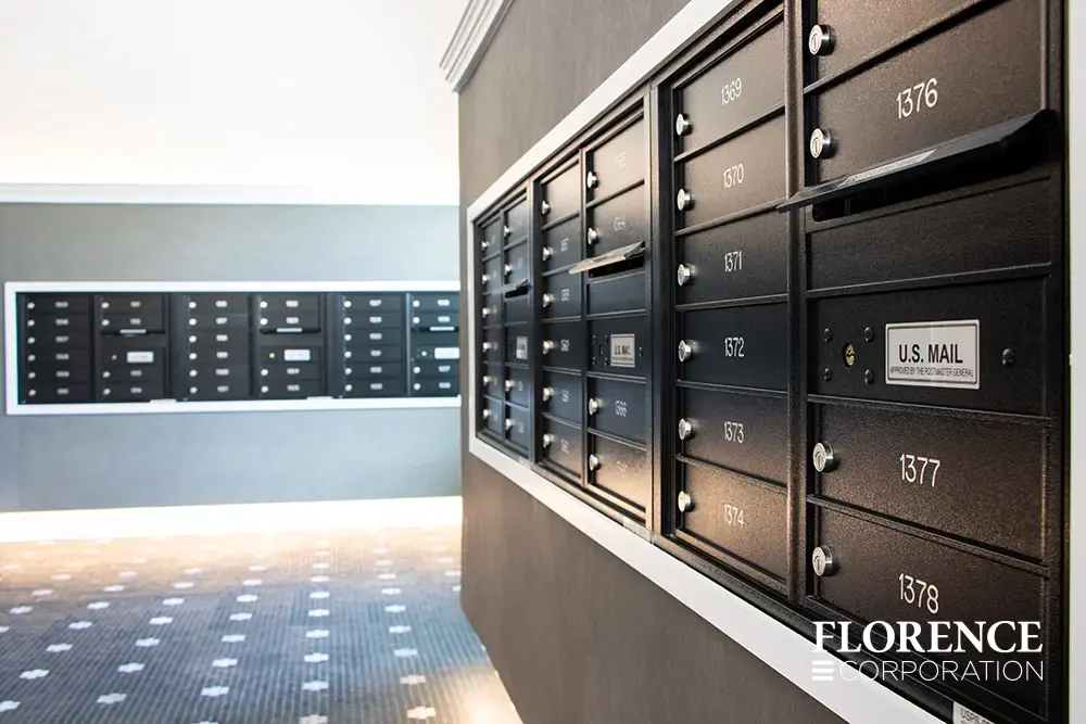 versatile-4C-indoor-install_003 Recessed mount versatile™ 4C mailboxes in black installed in multifamily apartment building modern mailroom with tile floor