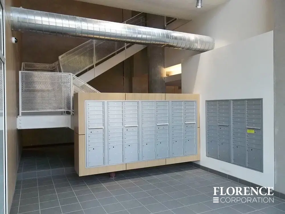 versatile-4C-indoor-install_013 Recessed mount versatile™ 4C mailboxes in silver speck in modern area with gray tile flooring, exposed metal duct work and metal railings on stairwell