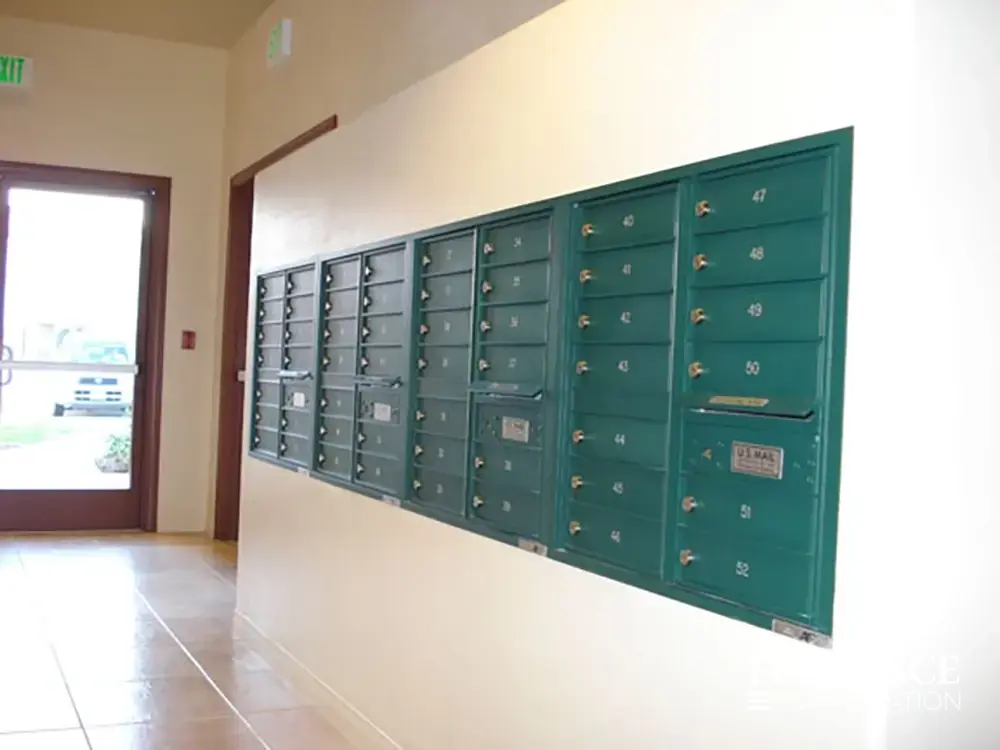 versatile-4C-indoor-install_017 Recessed mount versatile™ 4C mailboxes in forest green installed in white wall in multifamily apartment building near resident entrance