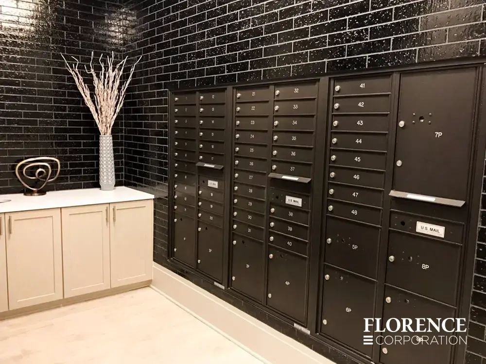 versatile-4C-indoor-install_018 Recessed mount versatile™ 4C mailboxes in dark bronze installed in black tile wall in modern lobby area of multifamily apartment building