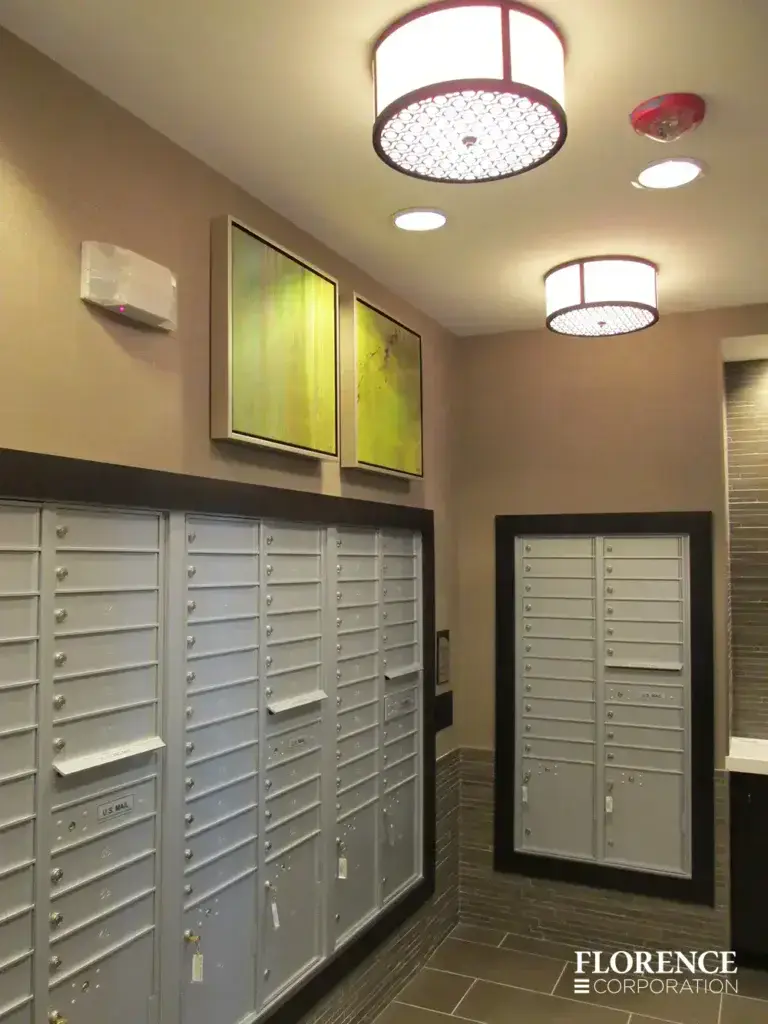 versatile-4C-indoor-install_021 Recessed mount versatile™ 4C mailboxes in silver speck edged with black frames installed in mailroom with tan walls, tile floor, lime green art and light fixtures on ceiling