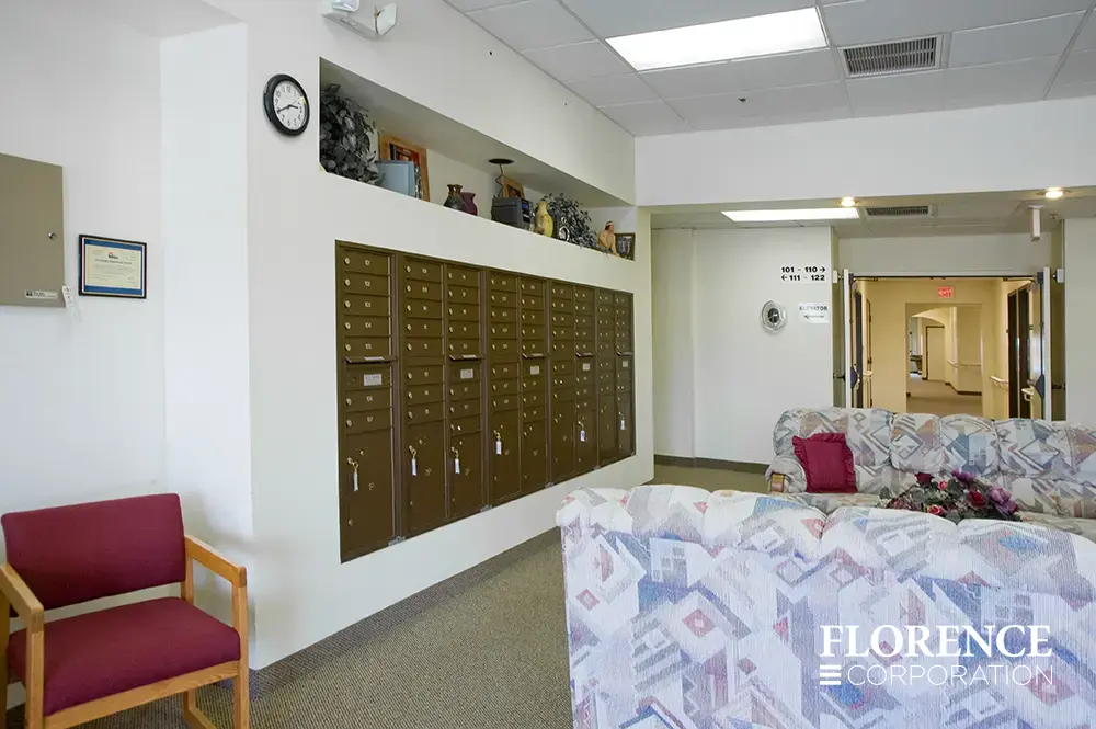versatile-4C-indoor-install_045 Recessed mount versatile™ 4C mailboxes in antique bronze installed in senior living home lobby area near couches and chairs