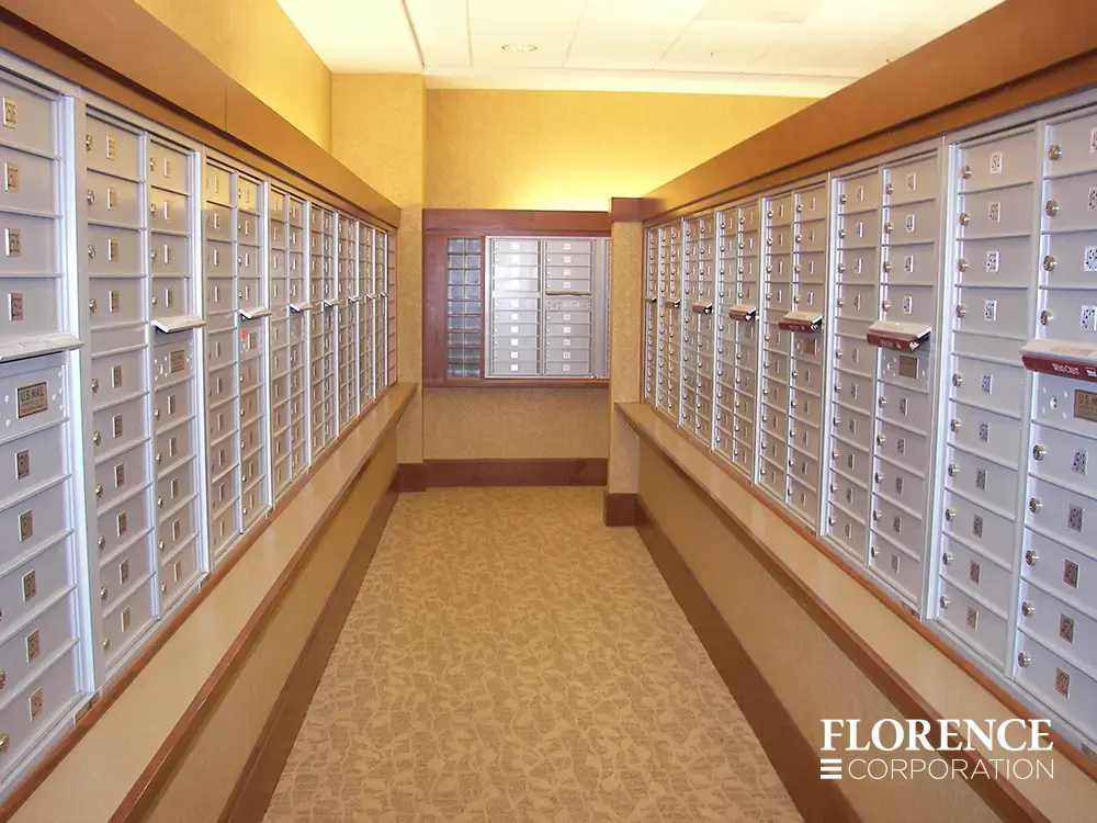 versatile-4C-indoor-install_048 Recessed mount versatile™ 4C mailboxes in silver speck installed in multifamily apartment mailroom with wood trip and floral carpeting