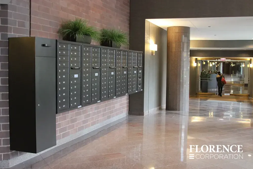 4C-versatile-surface-depot_003 surface mounted versatile™ 4C mailboxes and large collection box all in dark bronze mounted on indoor red brick wall with decorative plants in lobby of multifamily residential building