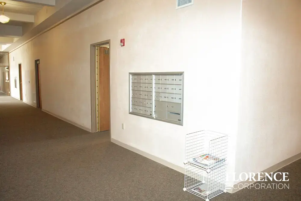 1400 Series 4B+ horizontal mailboxes in anodized aluminum installed on plain wall in senior living building hallway
