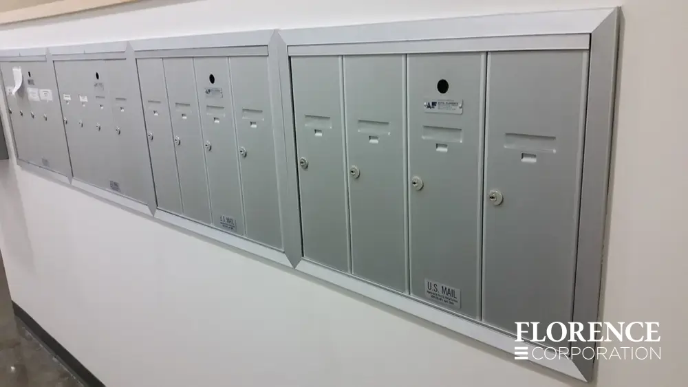 1250 recessed mounted vertical 4B+ mailboxes in anodized aluminum installed side by side along white wall inside of building
