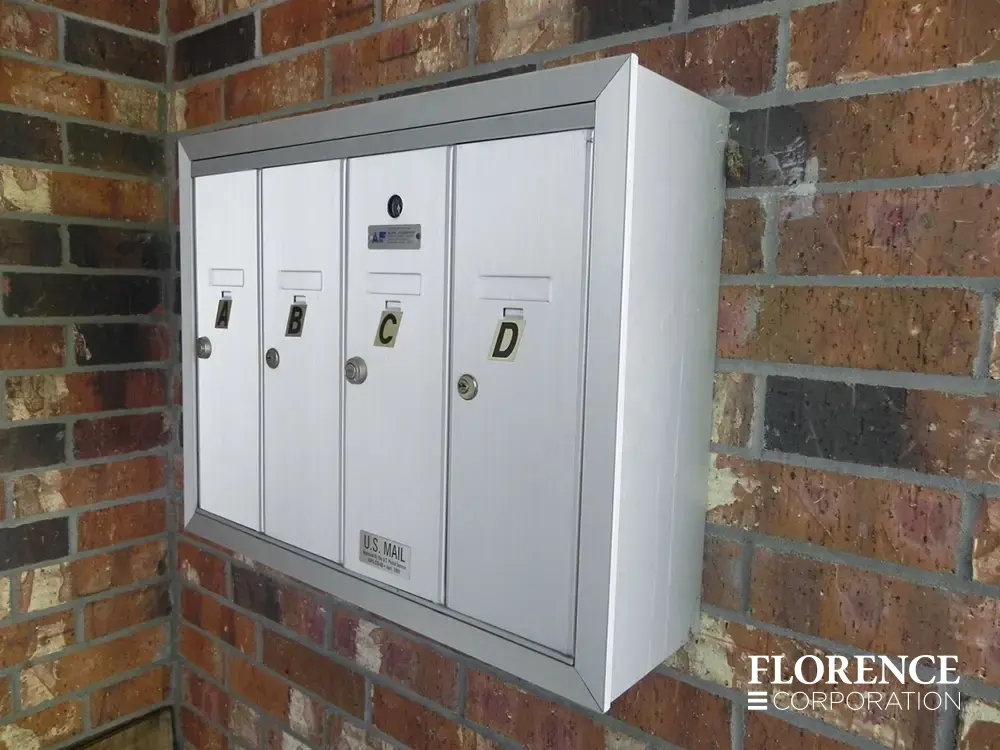 1250 surface mounted vertical mailboxes in anodized aluminum installed outside on brick multifamily apartment building