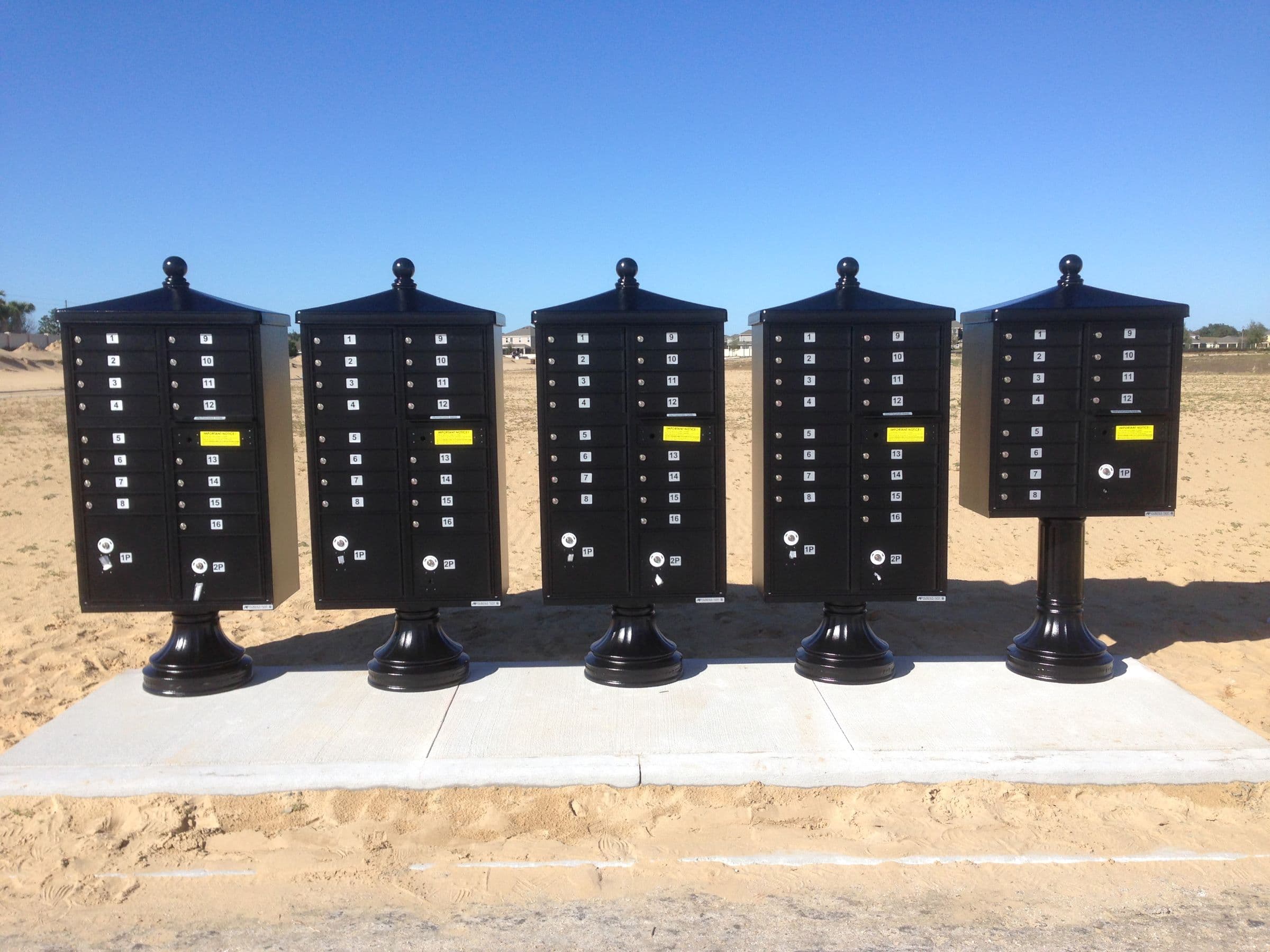 Black pedestal cluster mailboxes in new construction development.