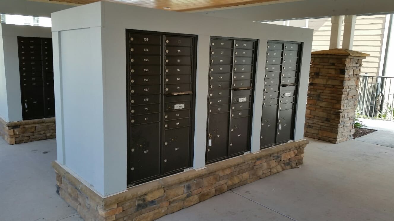 Outdoor 4C mailboxes are located under a covered area.